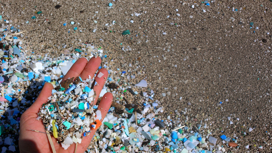 A handful of beach sand full of microplastics