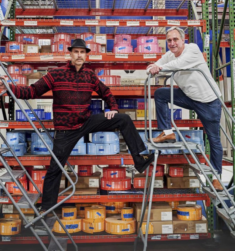 David and Michael Bronner on rolling ladders in the label warehouse